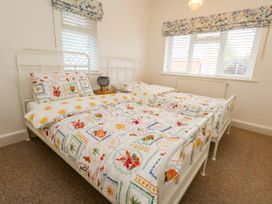 A bedroom with two single beds and a lamp at 29 Bincleaves Road in Weymouth