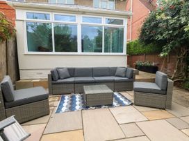 A garden with a sectional sofa and a coffee table at 29 Bincleaves Road Weymouth
