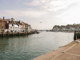 A harbor with boats and buildings along the shore at 29 Bincleaves Road Weymouth