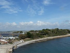 An ocean view with a promenade and buildings at Coast Path Cottage in Weymouth