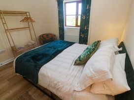 A bedroom with a bed and a clothes rack at Yonde View, Camborne