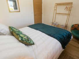 A bedroom with a bed and clothes rack at Yonde View Camborne