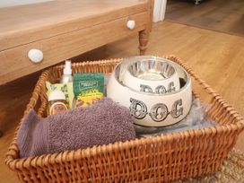 A basket with dog supplies including a bowl, towel, and treats at Yonde View in Camborne