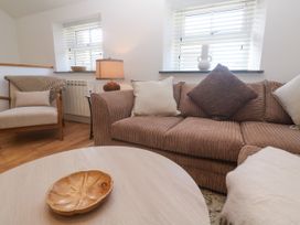 A living room with a sofa and armchair at Gews Farm Lodge St Just