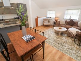 A living room with a coffee table, couch, and dining table at Gews Farm Lodge St Just