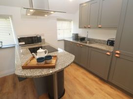 A kitchen with countertop, sink, and appliances at Gews Farm Lodge St Just