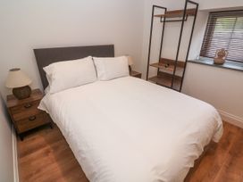A bedroom with a bed and nightstands at Gews Farm Lodge, St Just