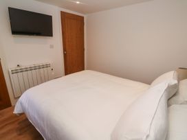 A bedroom with a bed and television at Gews Farm Lodge St Just