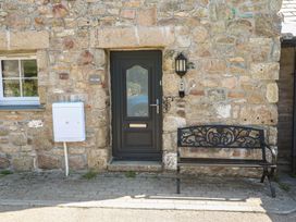 An entrance with a door and bench at Gews Farm Lodge in St Just