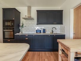 A kitchen with cabinets and appliances at Rollies Retreat in Fowey