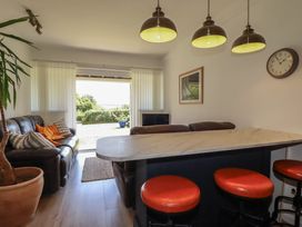 A living room with a sofa and bar stools at Rollies Retreat in Fowey