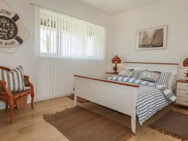 A bedroom with a bed and striped linens at Rollies Retreat in Fowey