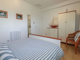 A bedroom with a bed and wardrobe at Rollies Retreat in Fowey
