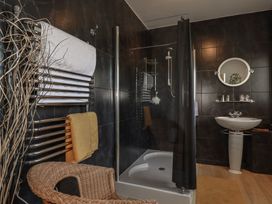 A bathroom with a shower and towel rack at Rollies Retreat in Fowey
