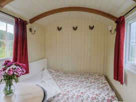 A bedroom with a bed and table at Shepherds Hut at East Hill Pride Four Elms Hill Nr. Sidmouth
