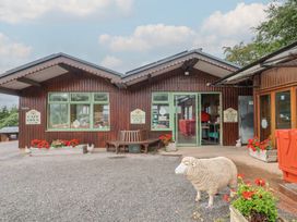 An outdoor area with a cafe open sign and flower pots at Shepherds Hut at East Hill Pride Four Elms Hill Nr. Sidmouth