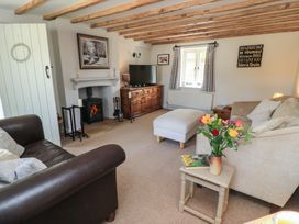 A living room with a sofa and a television at 2 The Gardens Lechlade