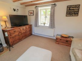 A living room with a television and cabinet at 2 The Gardens Lechlade