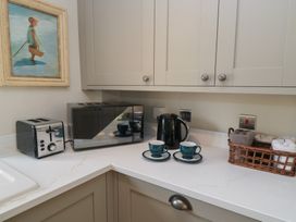 A kitchen with appliances and tea cups at 2 The Gardens Lechlade