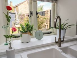 A kitchen with a view of a garden and decorative items at 2 The Gardens Lechlade