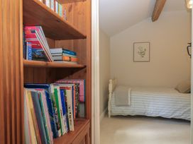 A bedroom with a bed and bookshelf at 2 The Gardens Lechlade