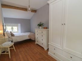 A bedroom with a bed, wardrobe, and window at 2 The Gardens, Lechlade