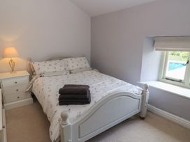 A bedroom with a bed and a lamp at 2 The Gardens in Lechlade