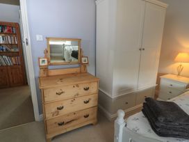 A bedroom with a dresser and a wardrobe at 2 The Gardens in Lechlade