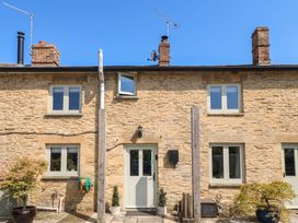 The front facade of a stone house with windows and door at 2 The Gardens Lechlade