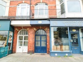 A building facade with doors and sign at Flat 3 in Llandudno