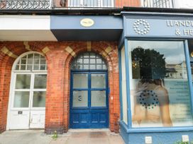 The entrance of a building with a blue door and signage at Flat 3 in Llandudno