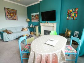 A living room with a sofa and a dining table at Flat 3 in Llandudno