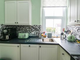 A kitchen with sink, toaster, and coffee maker at Flat 3 in Llandudno