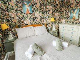 A bedroom with a bed and wall art at Flat 3 in Llandudno