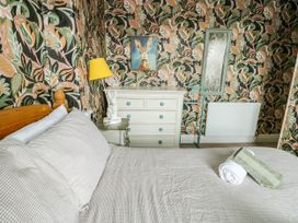 A bedroom with a bed and dresser at Flat 3 in Llandudno