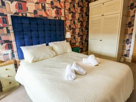 A bedroom with a bed and wardrobe at Flat 3 in Llandudno
