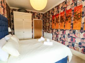 A bedroom with a bed and wardrobe at Flat 3 in Llandudno