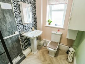 A bathroom with a shower, hand basin, and toilet at Flat 3 in Llandudno