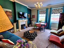 A living room with a television and fireplace at Flat 3 in Llandudno