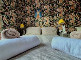 A bedroom with a bed and towels at Flat 3 in Llandudno