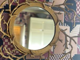 A mirror with a decorative frame in a living room at Flat 3 Llandudno