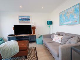 A living room with a television and a sofa at Trewollock in Mevagissey