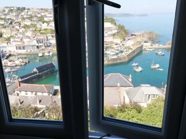 A view from a window overlooking a harbor with boats at Trewollock in Mevagissey