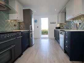 A kitchen with an oven, refrigerator, and sink at Trewollock in Mevagissey