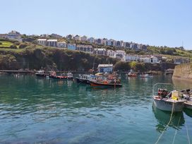 A view of boats in water with houses on hills at Trewollock in Mevagissey