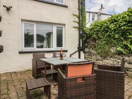 An outdoor seating area with a table and chairs at Courtyard Cottage