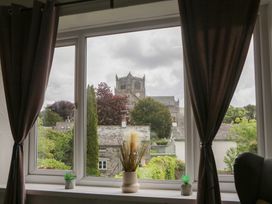 A window view showing a church and greenery at Courtyard Cottage