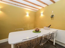 A dining room with a table and chairs at Courtyard Cottage