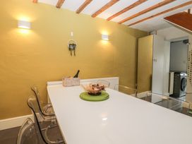 A dining room with a white table and chairs at Courtyard Cottage