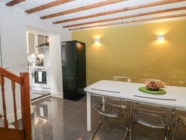 A kitchen with a dining table and chairs at Courtyard Cottage 